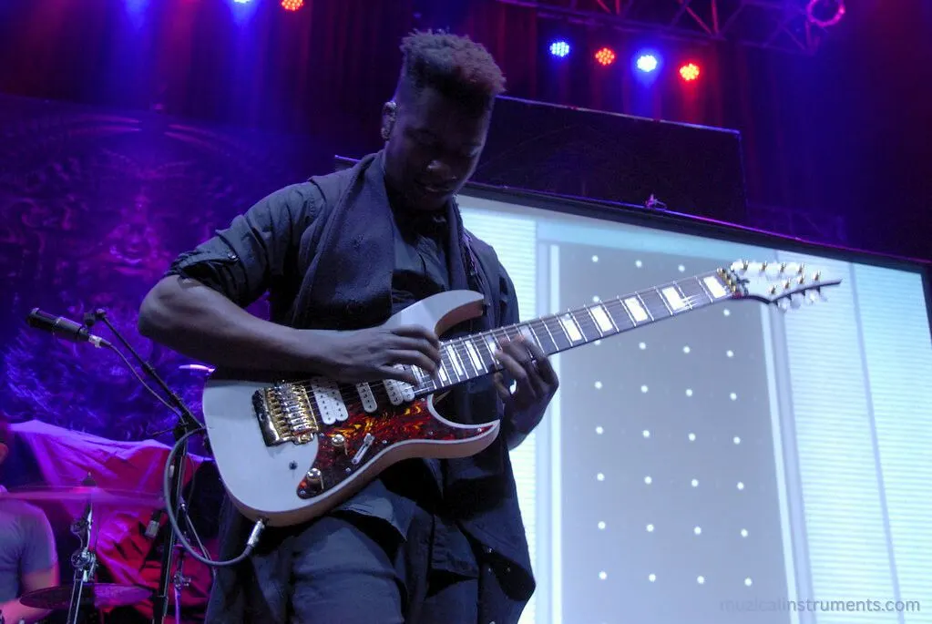 Tosin Abasi playing an 8 string guitar